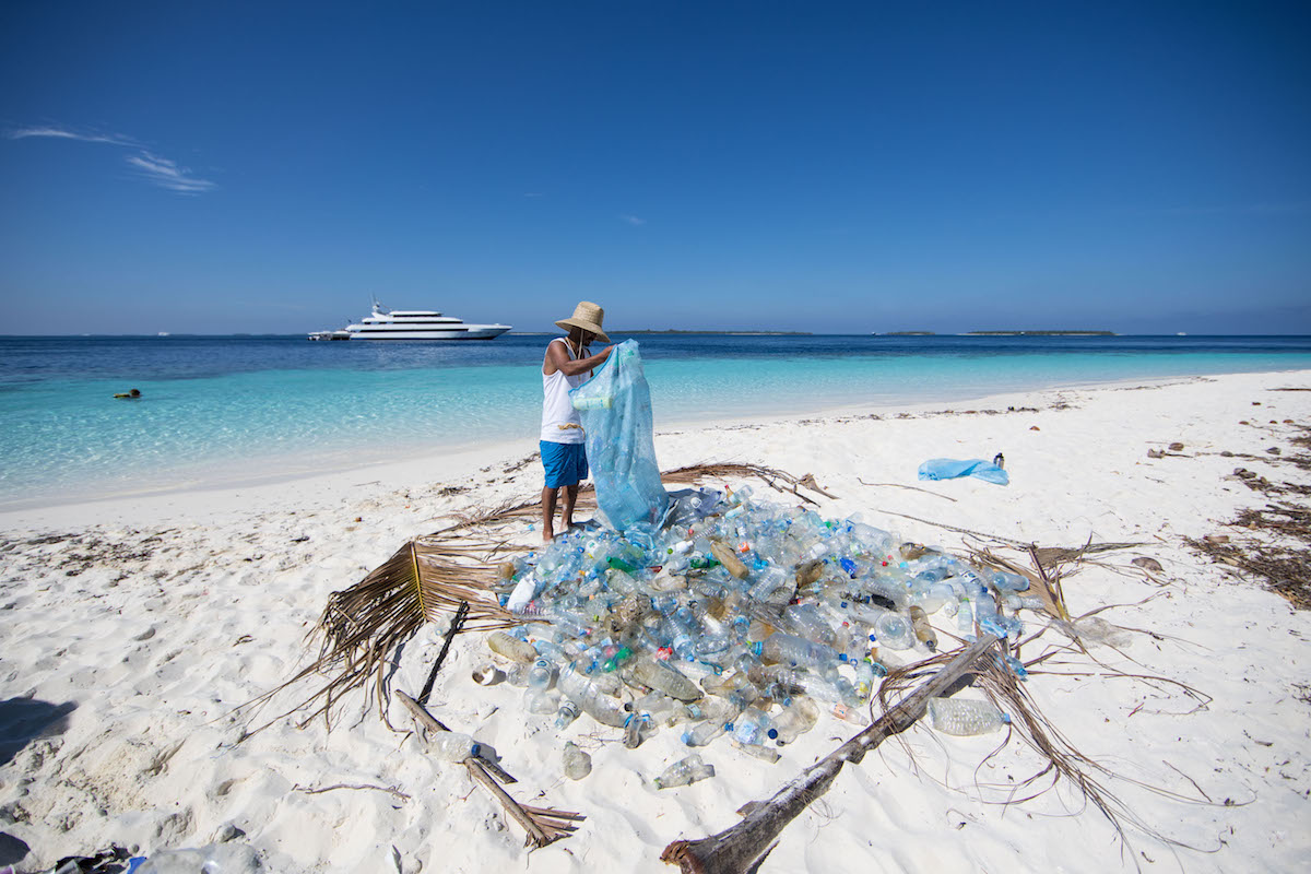 Chilean surfer Ramon Navarro collecting plastics on a beach in the Maldives. Photo: Corona and Parley for the Oceans